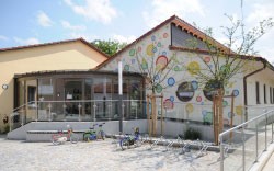 Das Bild zeigt den Garten und im Hintergrund den Kindergarten St. Stephanus